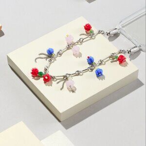 Ossa New York clear iPhone 14 Pro Max case and Blooms Bar Chain Wristlet